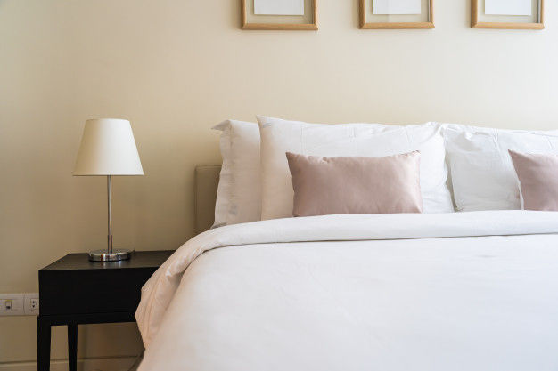 white plumped up pillows on a double bed with white bedding